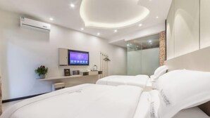 Een moderne hotelkamer met een groot bed, een televisie en een spiegel.
