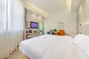 A hotel room with a bed, a TV, a chair, and a desk. - Mile Dream Tour Boutique Hotel (Mile)