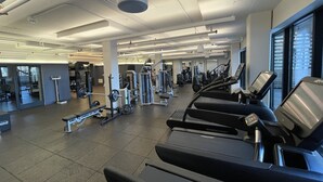 Una sala de gimnàstica moderna amb cintes de córrer, aparells de musculació i equipament esportiu.