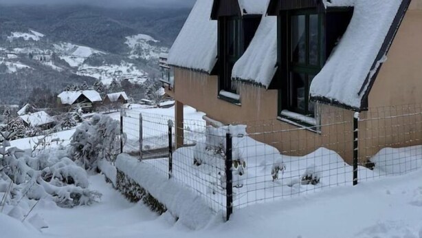 A house with a steeply pitched roof covered in snow, surrounded by a snowy landscape and a cloudy sky. - Chalet-style house in the heart of nature (Kruth)
