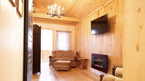 Un interior de madera con un sofá, un televisor y una chimenea.