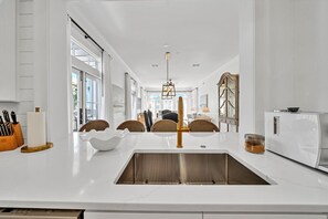 Enjoy meals in the kitchen with a central island, stainless steel sink, and dining area.