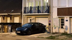 Kaksikerroksinen rakennus, jonka edessä on parkkeerattu auto.