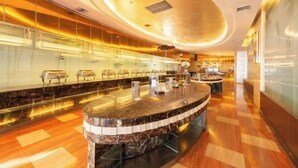 Un moderno vestíbulo de hotel con un mostrador de recepción curvo, zona de estar y un separador de vidrio.
