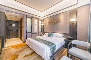 A modern hotel room with a large bed, a desk, and a chair. There is a walk-in closet and a bathroom visible in the background. - Dihao International Hotel (Guang'an)
