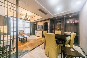 A modern hotel room with a dining area, a piano, and a minibar. - Dihao International Hotel (Guang'an)