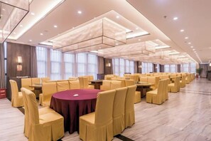 A spacious banquet hall with round tables and yellow chairs, large windows, and a modern ceiling design. - Dihao International Hotel (Guang'an)
