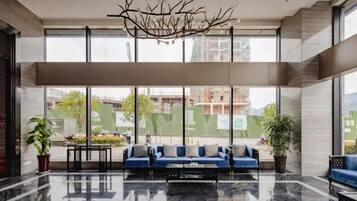 A modern lobby with a seating area, large windows, and a reflective floor.