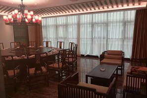 A hotel dining area with a round table, chairs, and a sofa. - Dihao International Hotel (Guang'an)