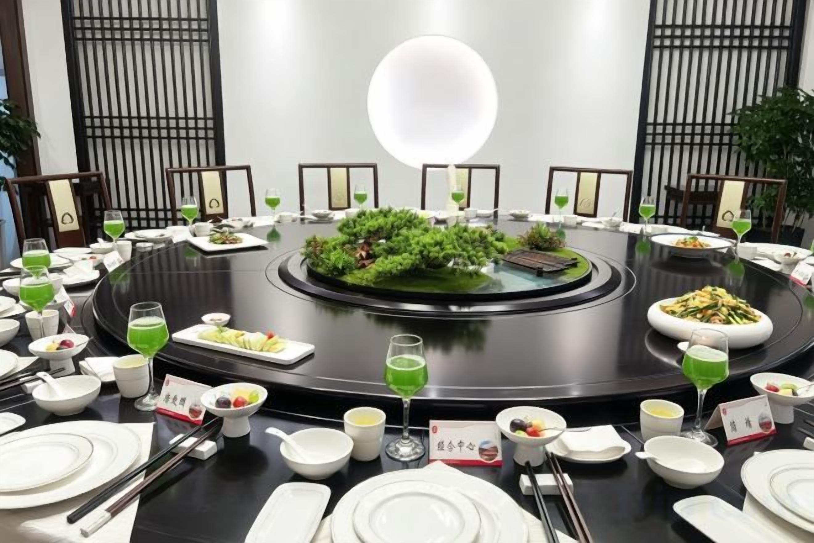 A round dining table with various dishes and drinks, surrounded by chairs.