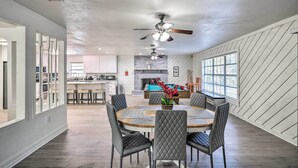 A spacious dining area with a round table, cushioned chairs, and a ceiling fan. - Spacious Family Home w/ Backyard in Gainesville! (Gainesville)