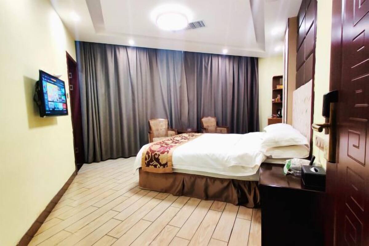Une chambre d’hôtel équipée d’un lit, d’une télévision, d’un bureau et d’une armoire.