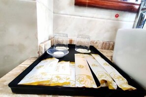 Ein Tablett mit Teebeuteln und Gläsern auf einer Marmorplatte.