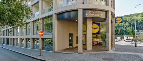 A modern building with a Lidl store on the ground floor, featuring large windows and a visible entrance.
