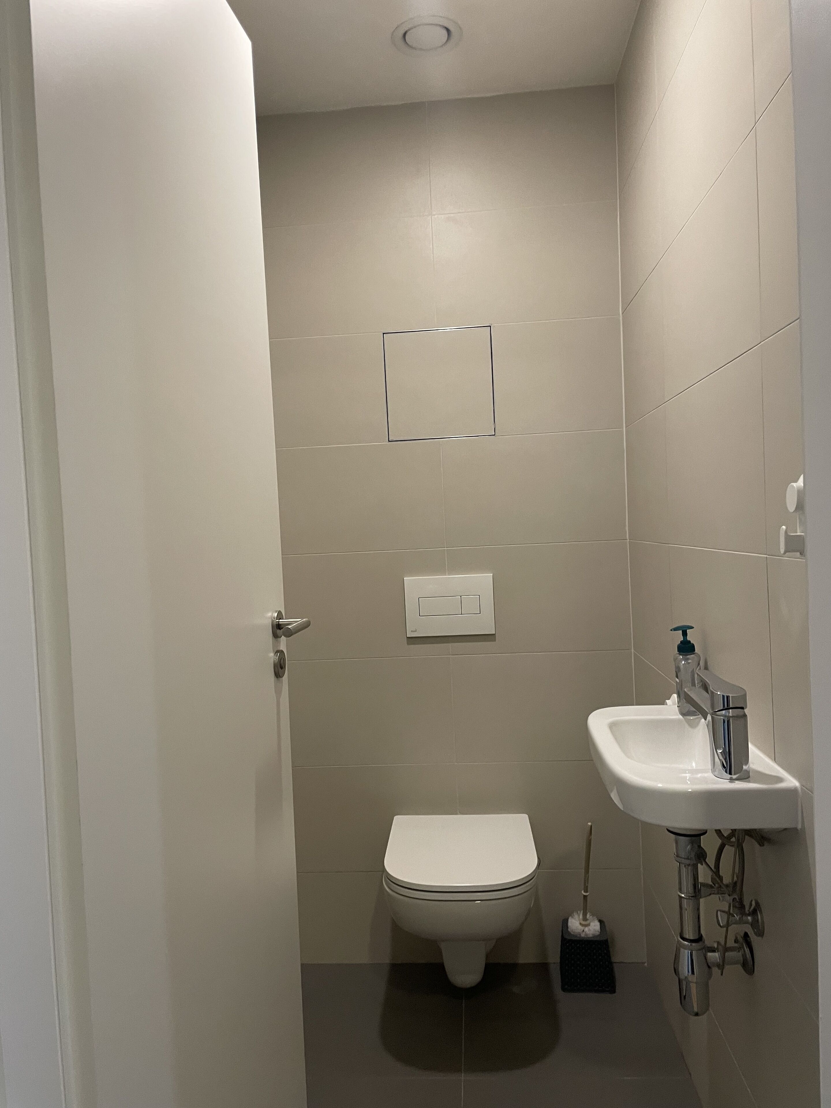 Une petite salle de bain avec des toilettes, un lavabo et un miroir.