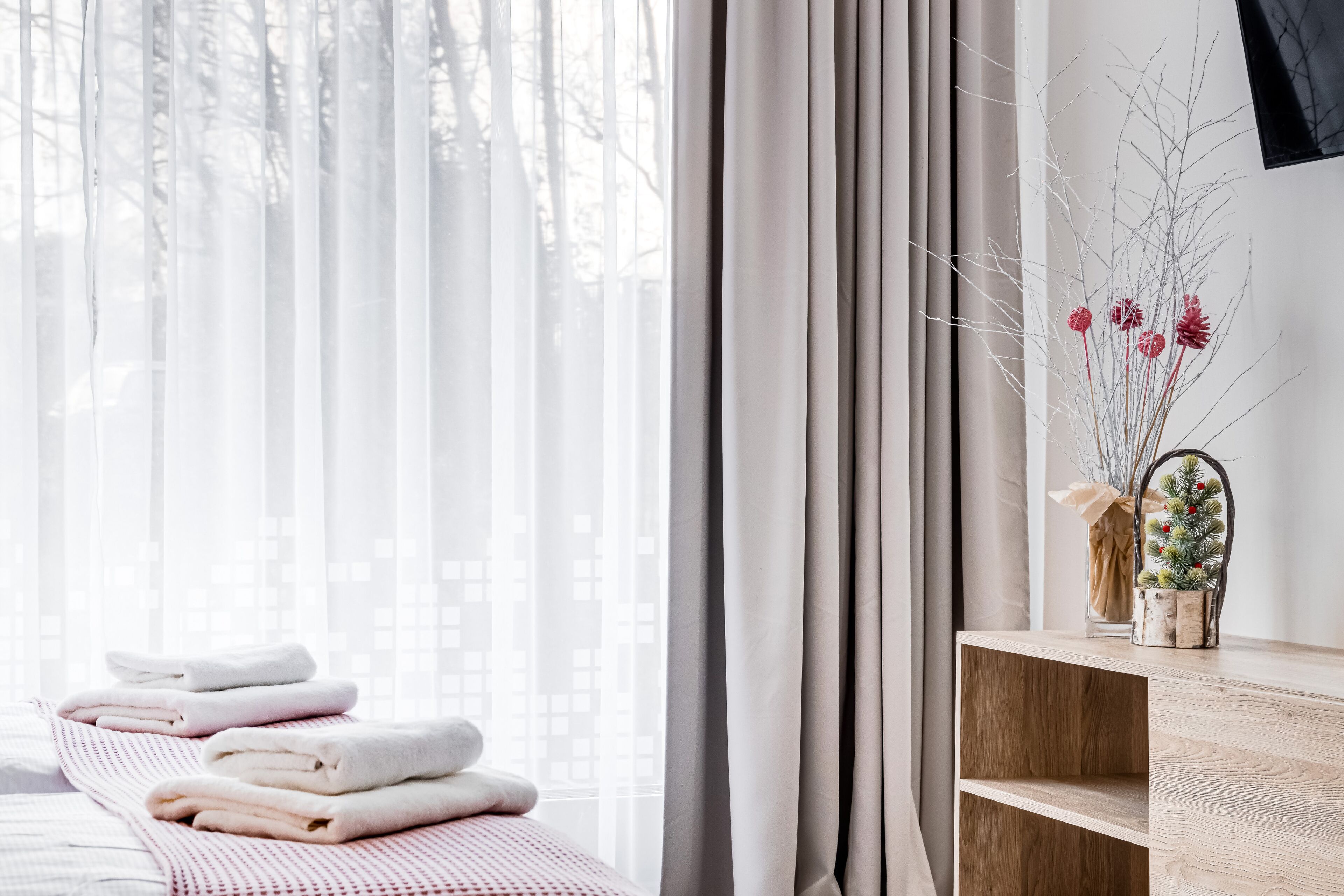 Un baño ordenado con toallas, un estante de madera y una planta decorativa.