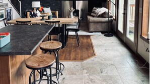 A modern kitchen with a wooden ceiling, a black backsplash, and a large window. - Cleveland Cabin with Mountain Views & Lake Access (Rexford)