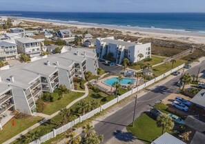 Hotel à beira-mar com piscina, vários edifícios e vista para a praia.