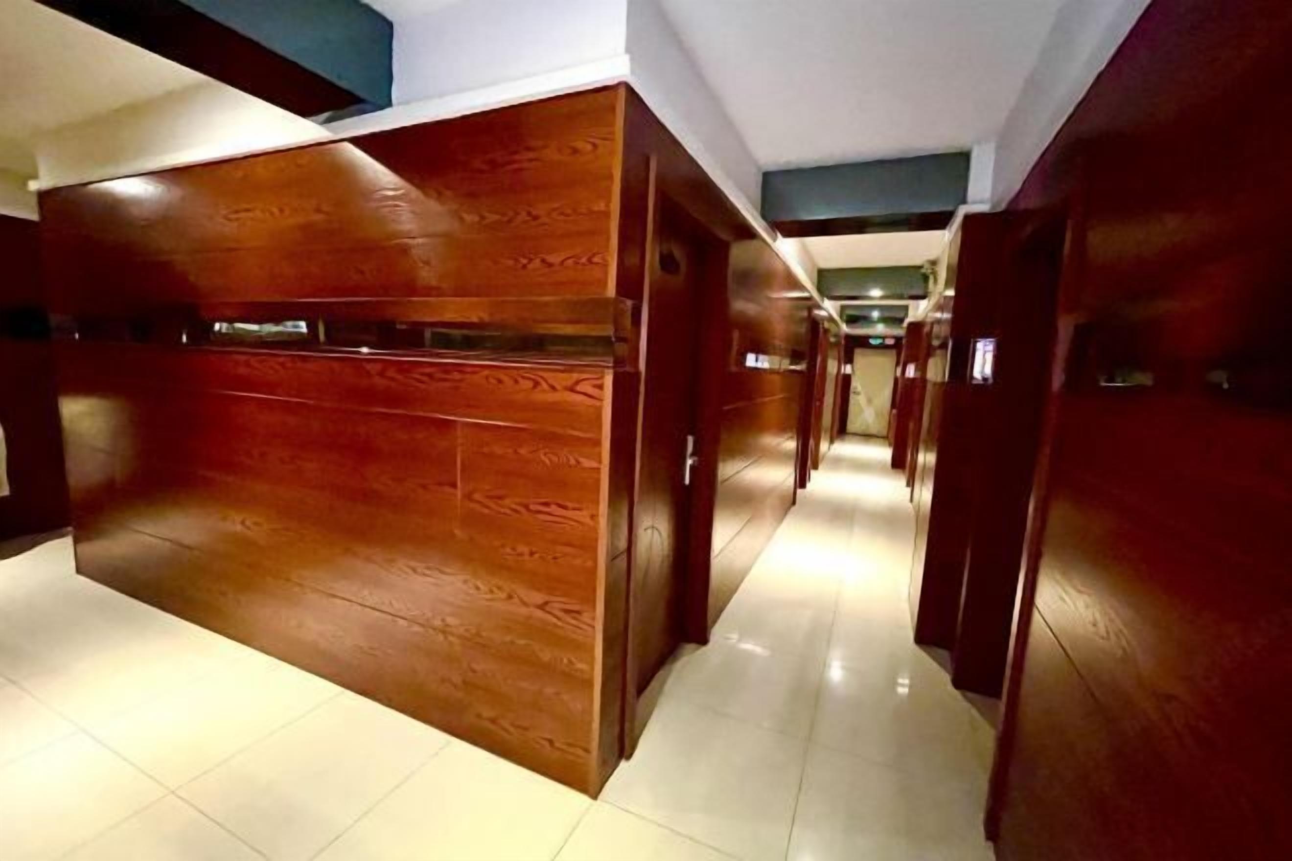 A hallway with wooden paneling and a tiled floor.