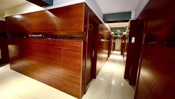 A hallway with wooden paneling and a tiled floor.