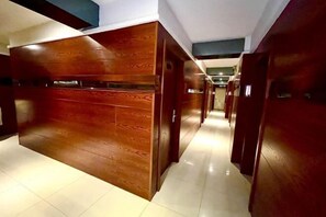 A hallway with wooden paneling and a tiled floor. - Jinyi Business Hotel (Changchun)