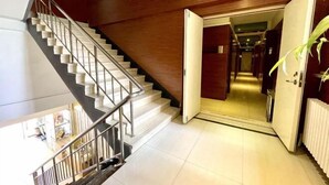 A staircase with a metal railing leading to a landing. - Jinyi Business Hotel (Changchun)