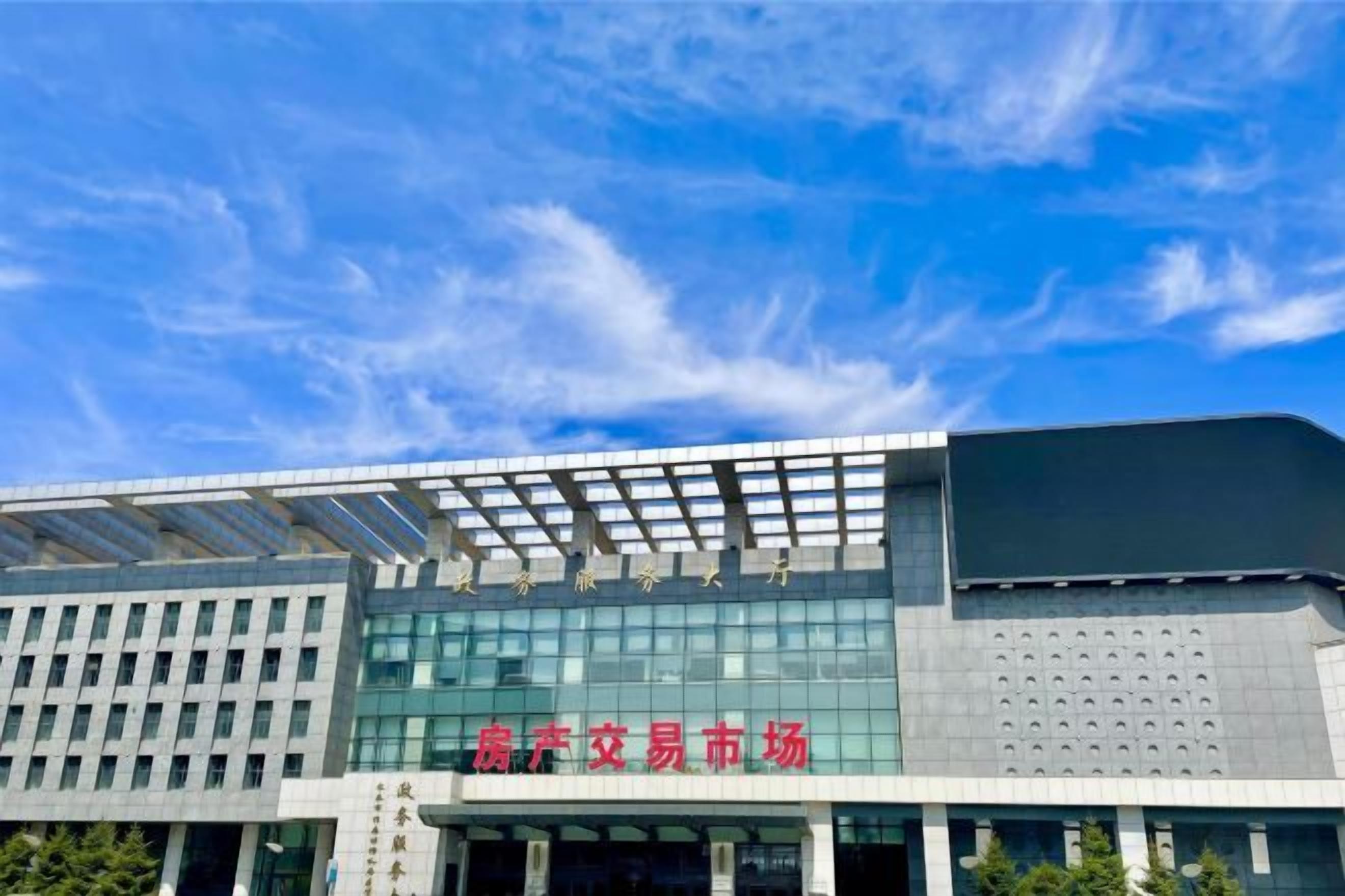 A modern building with a large glass facade and a sign indicating it is a commercial market.