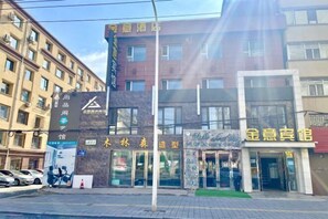 A hotel with multiple storefronts, including a visible sign for a spa and a clothing store. - Jinyi Business Hotel (Changchun)