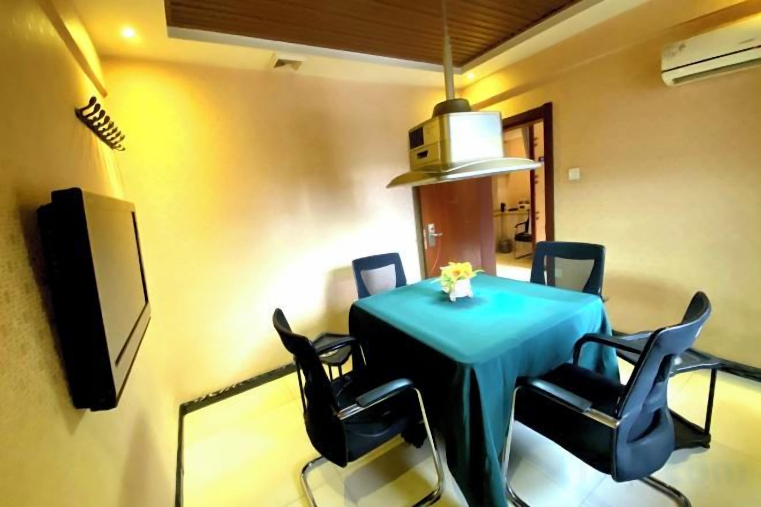Uma sala de jantar com mesa, cadeiras e ventilador de teto.