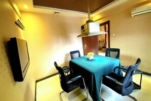 A dining area with a table, chairs, and a ceiling fan. - Jinyi Business Hotel (Changchun)