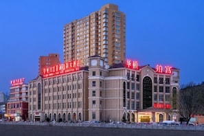 Un hotel de varios pisos con un edificio central destacado y varias construcciones más pequeñas.