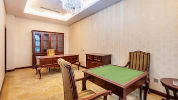A room with a pool table, a cabinet, and a chair.
