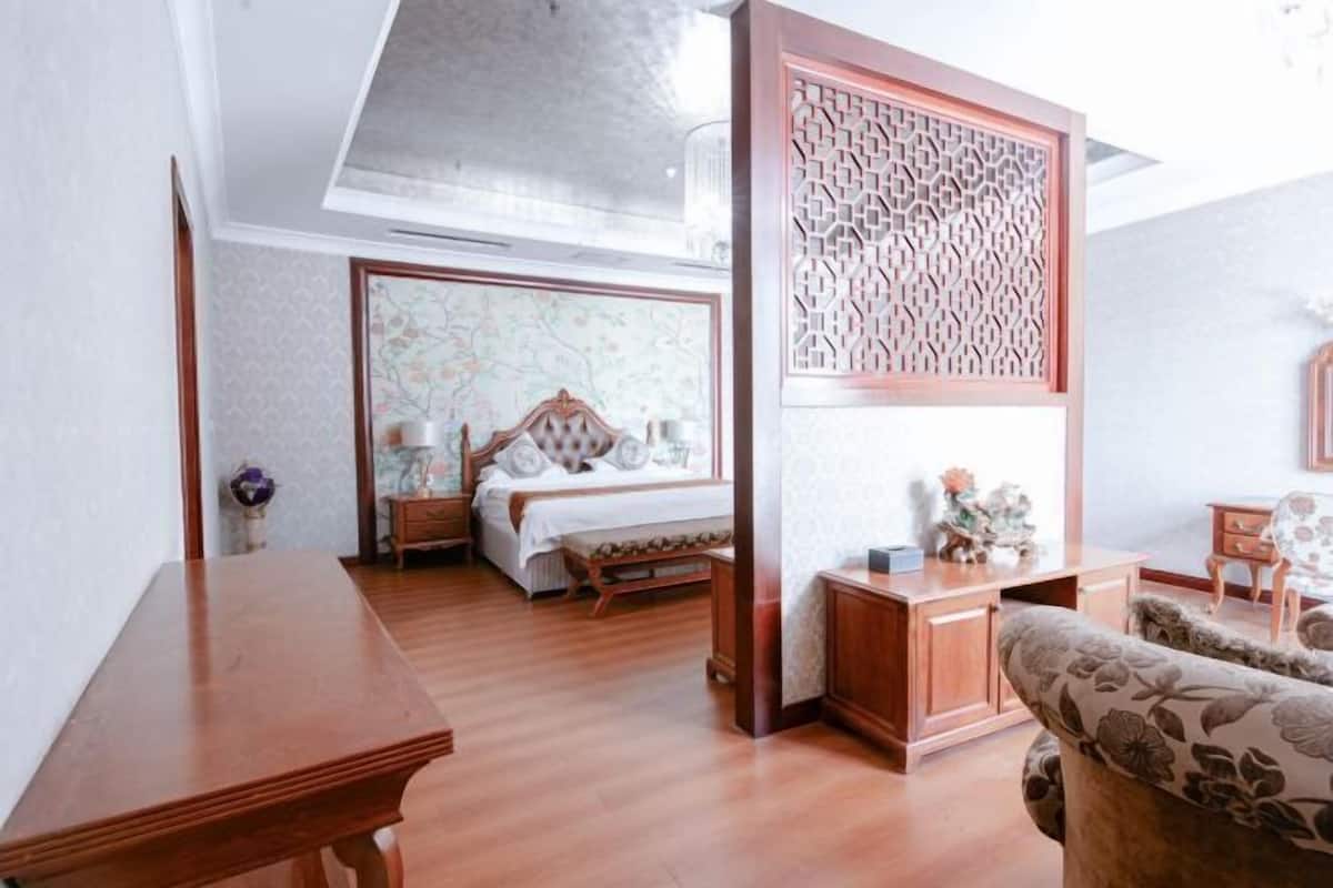 Ein Hotelzimmer mit einem hölzernen Bett, einem Schreibtisch und einer Couch.