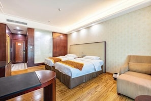 Una habitación de hotel con una cama, un sofá, un escritorio y un espejo.
