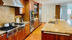 A modern kitchen with wooden cabinets, stainless steel appliances, and a granite countertop. - Family Retreat in the Heart of Wine Country  (Santa Rosa)