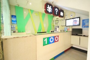 A reception desk with a number sign, a clock, and a television screen. - 100 Hotel (Guangzhou Panyu Shiqiao Metro Station) (Guangzhou)