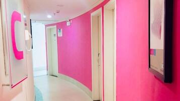 Un pasillo con techo curvo y pared rosa.
