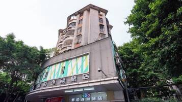 A multi-story building with a commercial ground floor featuring signage for a store and a restaurant.