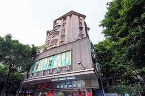 A multi-story building with a commercial ground floor featuring signage for a store and a restaurant. - 100 Hotel (Guangzhou Panyu Shiqiao Metro Station) (Guangzhou)