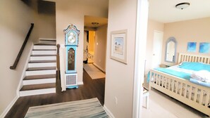 Una escalera con un tapete estampado que conduce a un dormitorio con una cuna.