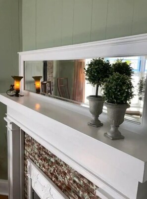 Cozy fireplace with a mantelpiece featuring a candle holder and a potted plant.