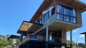 Un immeuble moderne à deux étages, doté de grandes fenêtres et d’un balcon.