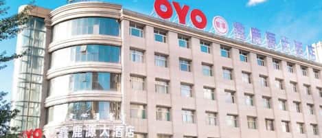 A hotel with a prominent 'OYO' sign, multiple floors, and a curved corner structure.
