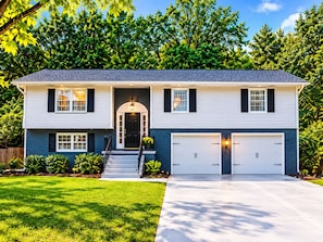 A two-story house with a front entrance, two garage doors, and a well-maintained lawn. - ATL Lakeview Retreat - Holiday Getaway (Decatur)