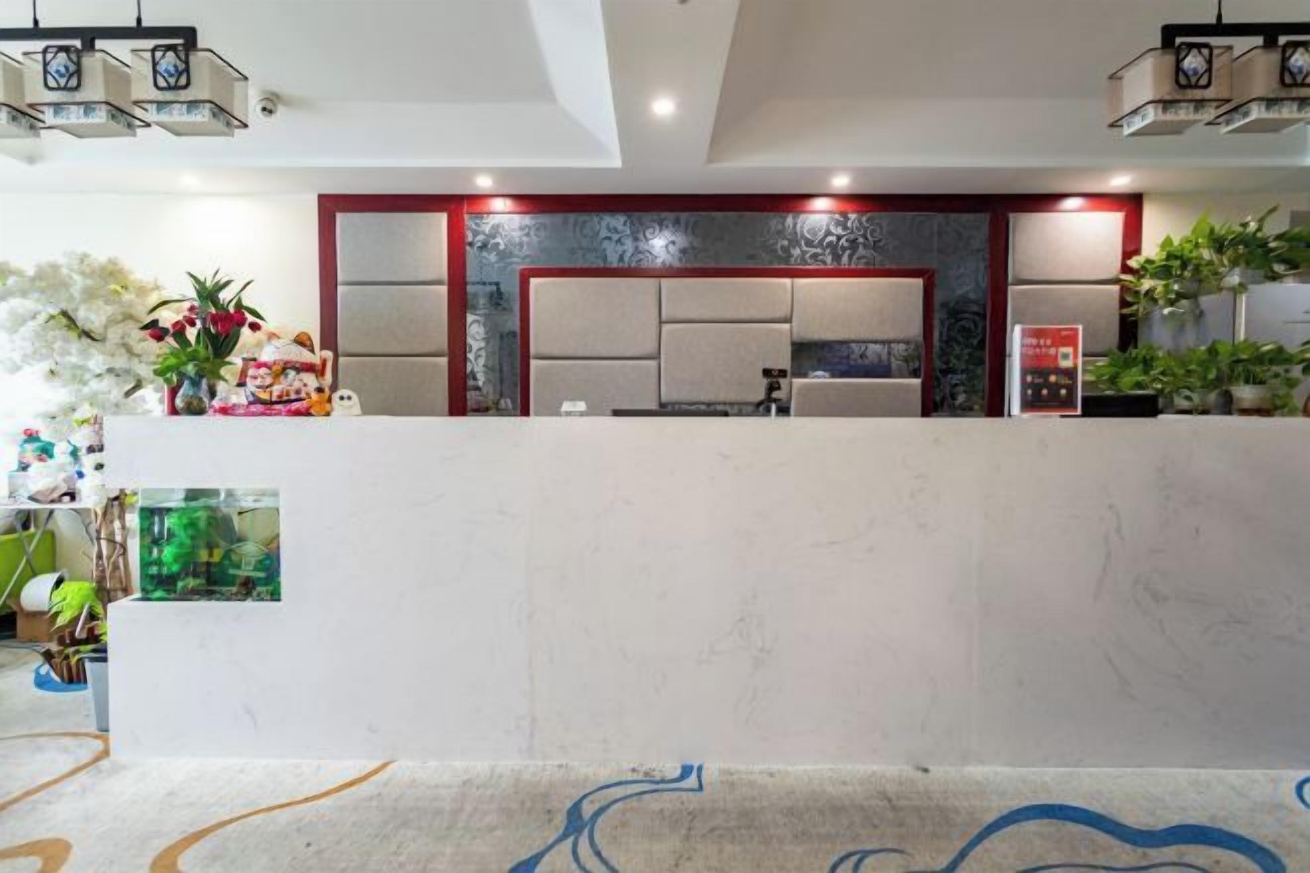 A reception area with a marble counter, seating, and decorative plants.