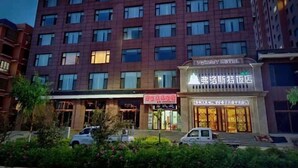 A hotel with multiple floors, a prominent sign for the hotel, and a well-maintained garden area in front.
