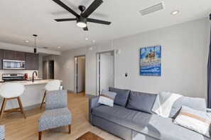 A modern living room with a grey sofa, patterned chairs, and a ceiling fan. - 175 LEX - Spacious Two Bedroom! Walkable Downtown! (Lexington)
