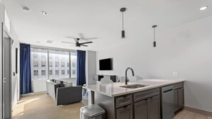 A modern kitchen with a central island, built-in cabinets, and a ceiling fan. - 175 LEX - Spacious Two Bedroom! Walkable Downtown! (Lexington)