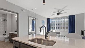 A modern kitchen with a large island, a built-in sink, and a ceiling fan. - 175 LEX - Spacious Two Bedroom! Walkable Downtown! (Lexington)