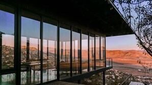 Un edificio moderno con amplios ventanales que ofrecen vistas a un paisaje montañoso.